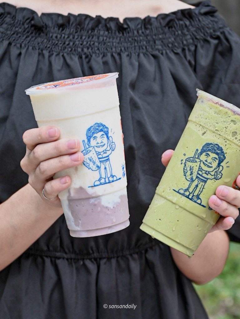 雙手拿著紅茶屋飲料的人