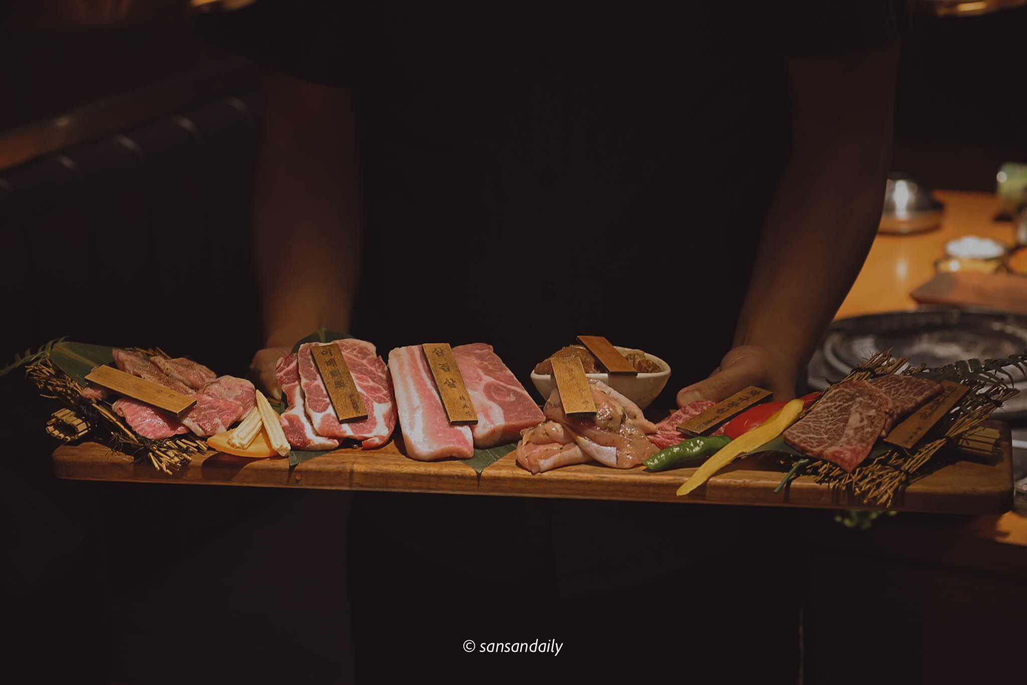 男子端著一盤長長的燒肉生肉片