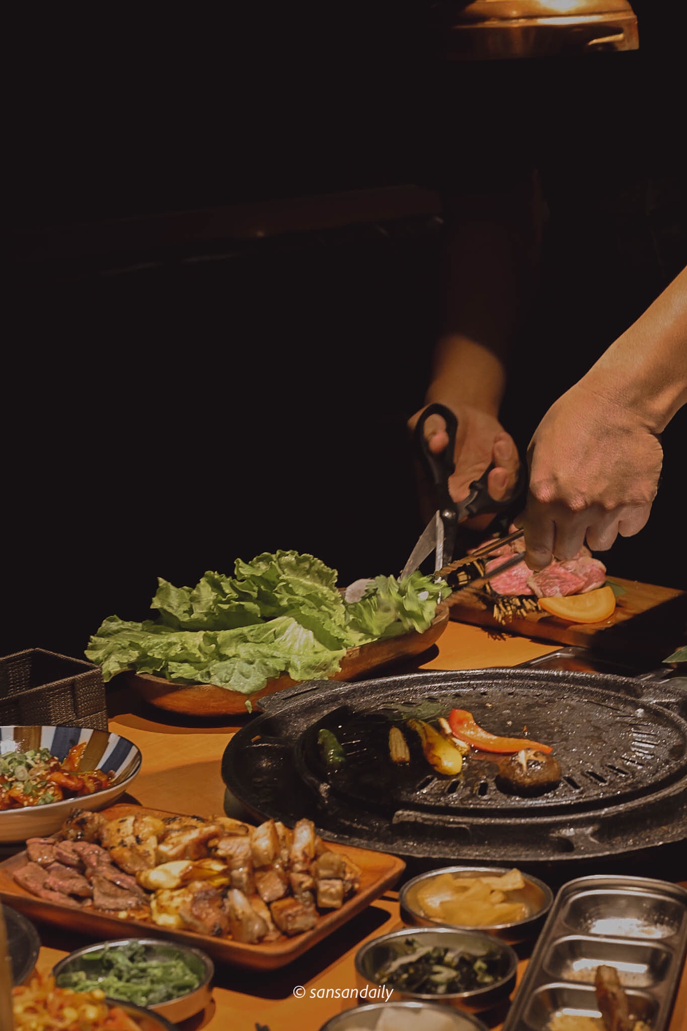 餐桌上一個人用剪刀剪生菜