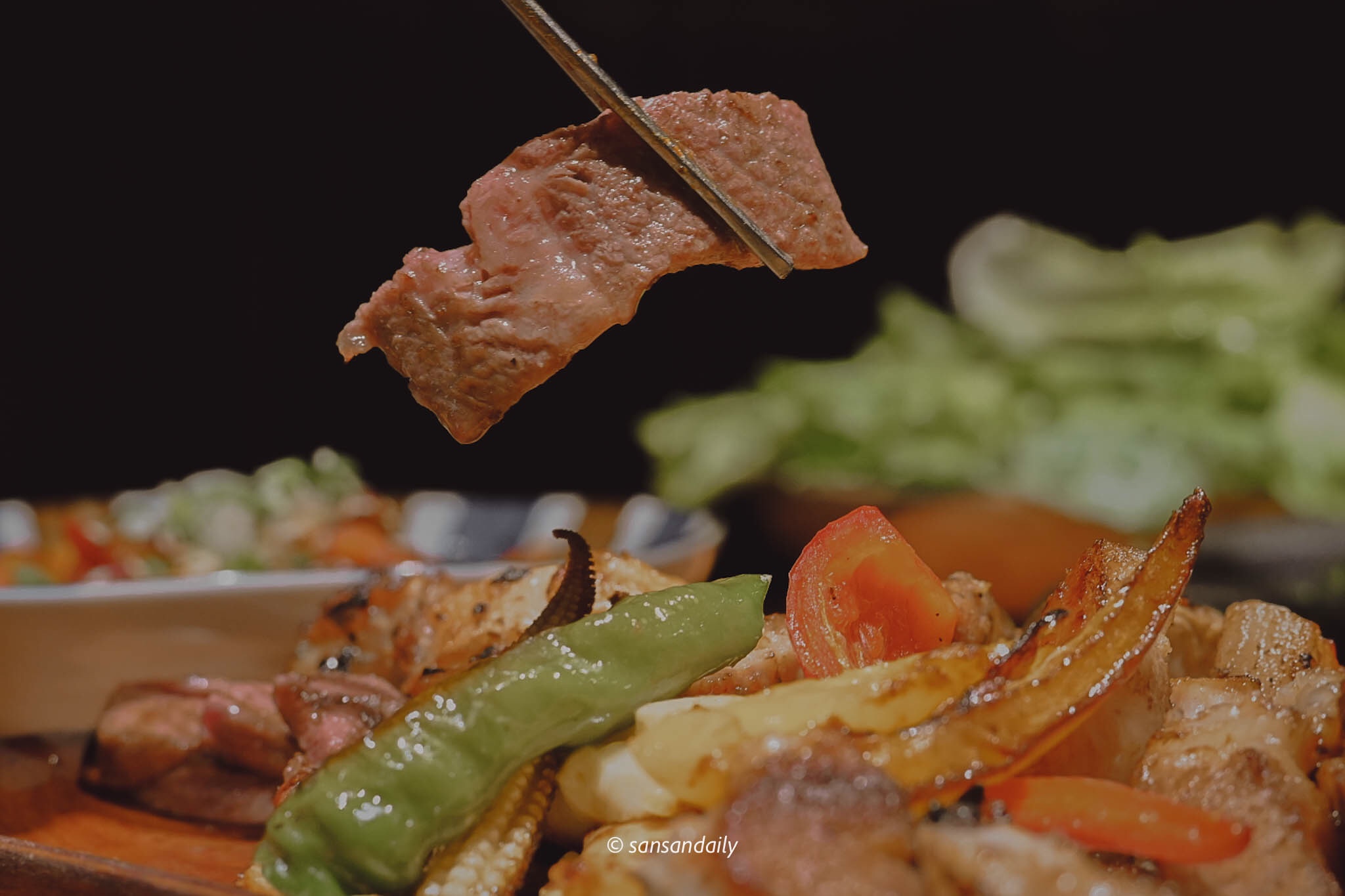 筷子夾起一片烤好的和牛翼板肉