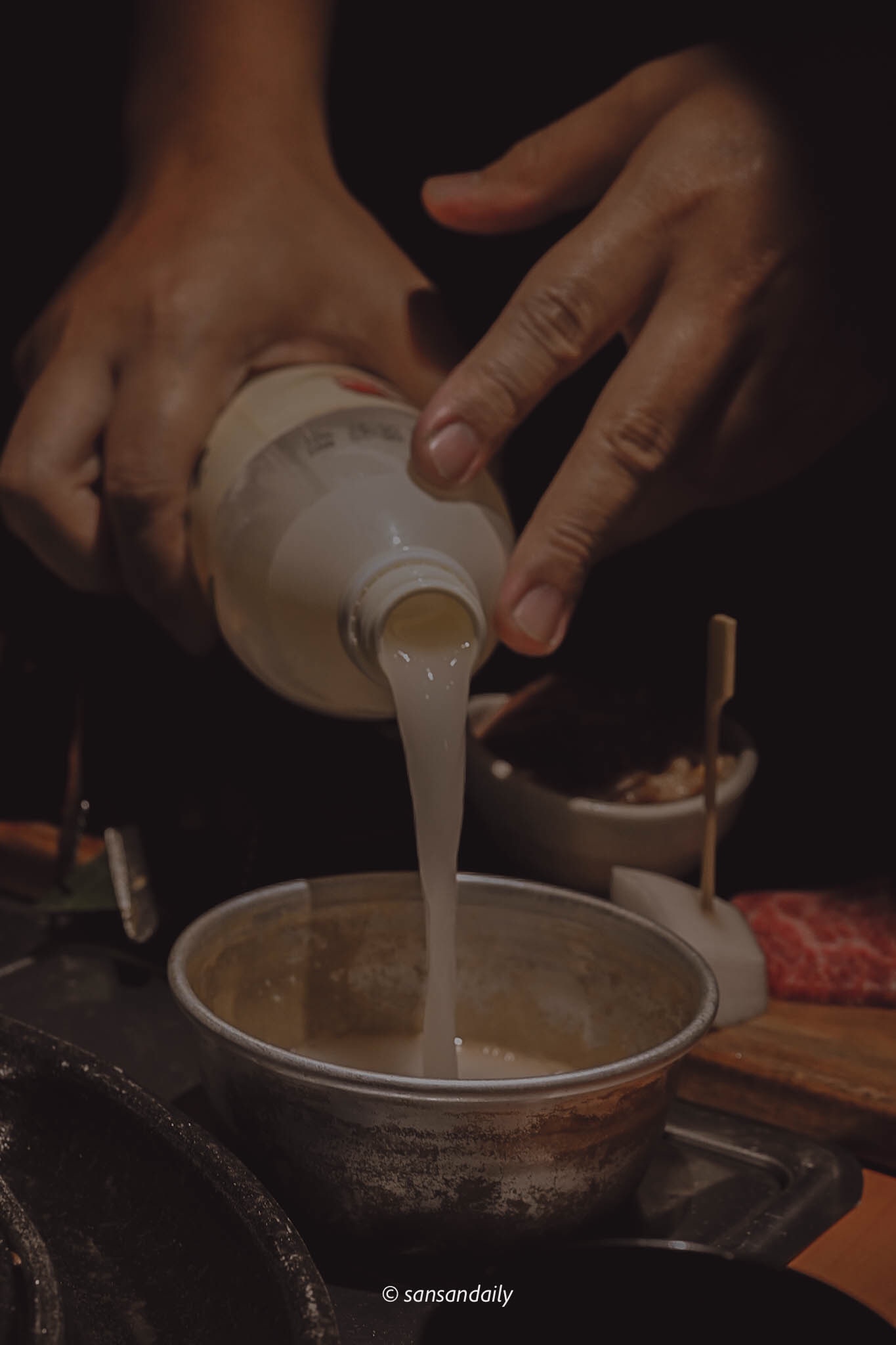 一個人將馬格利倒入在桌上的鋁碗