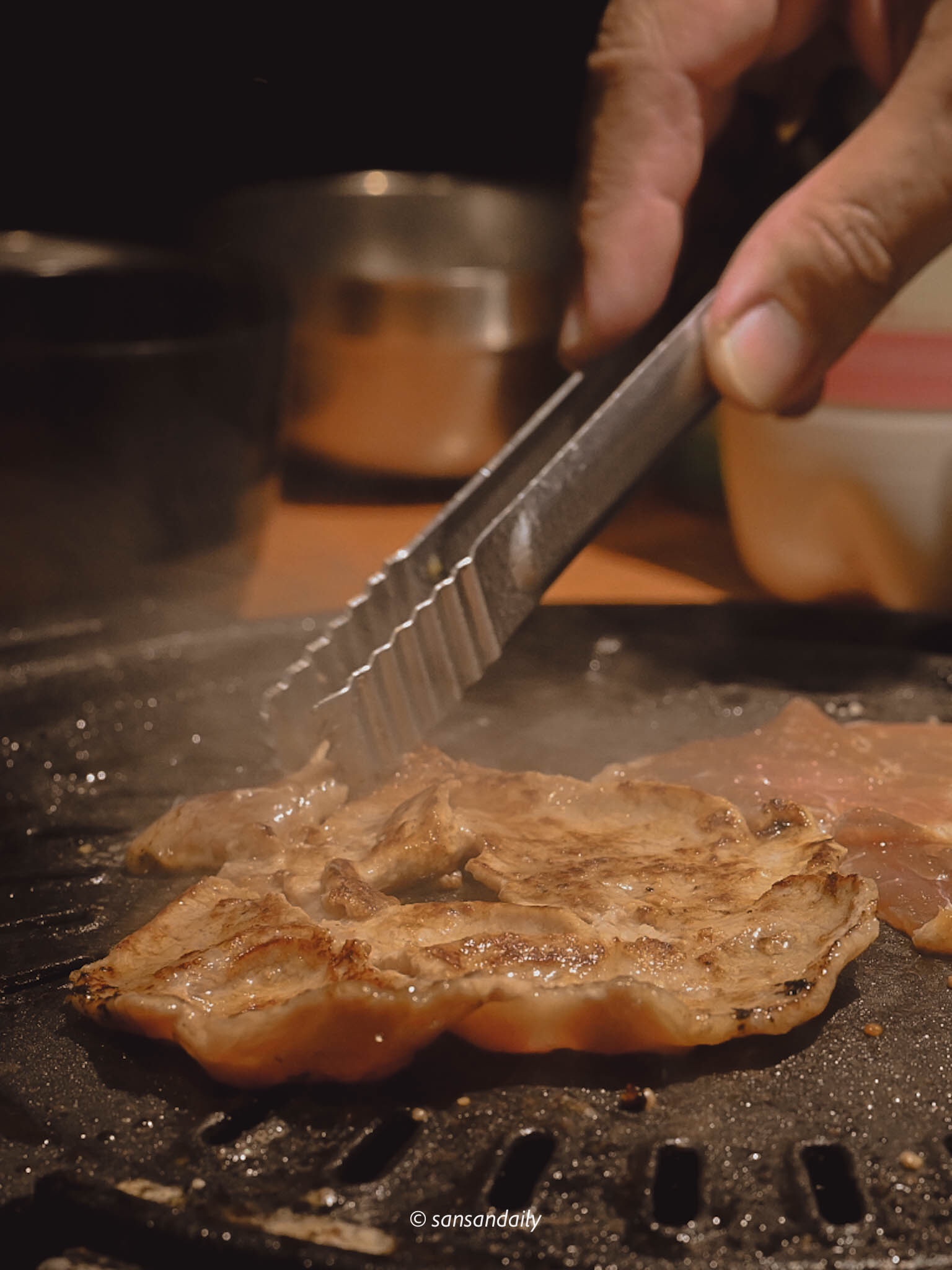 準備在鐵盤上翻面的娘子秘製豬肉