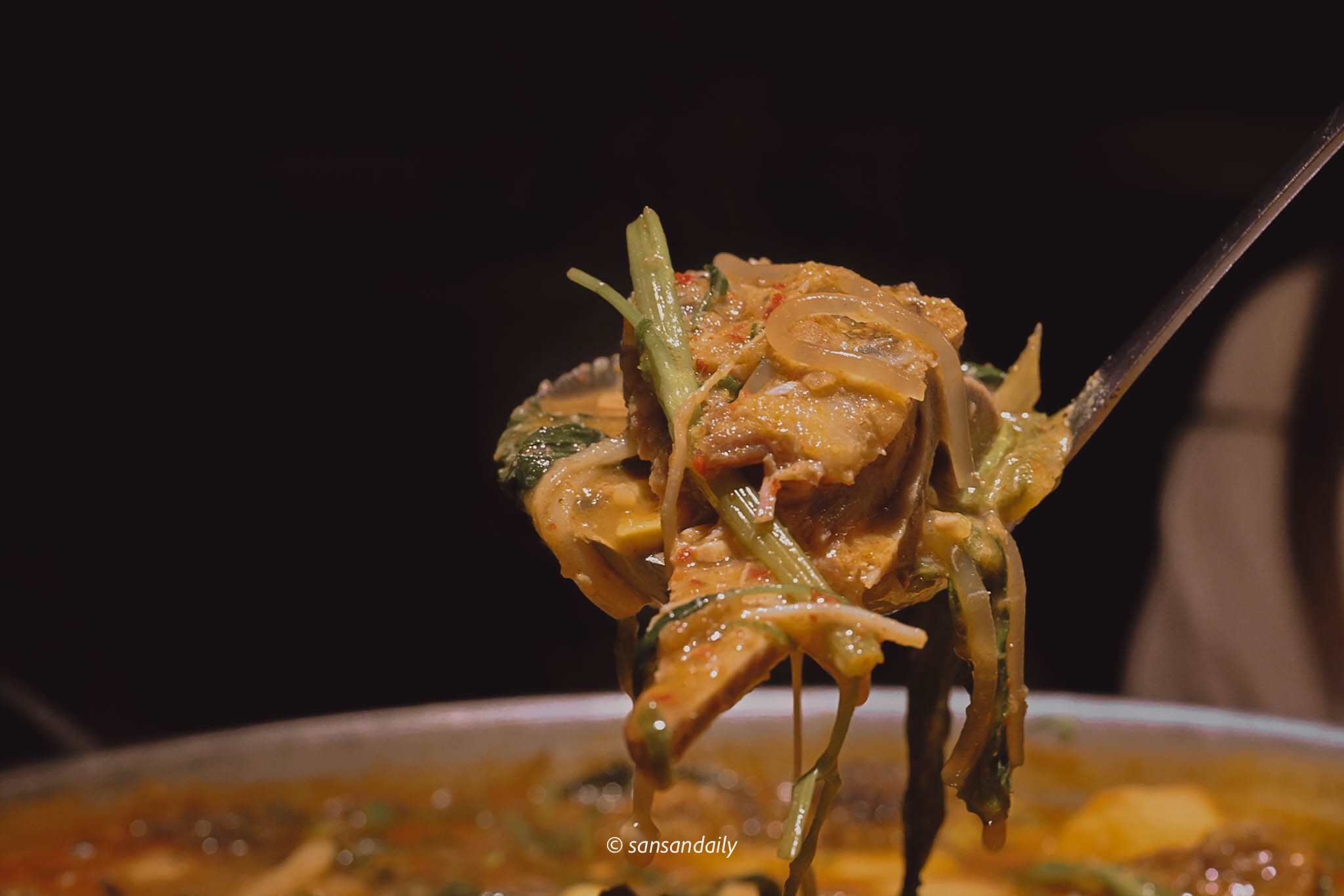 湯匙舀起一勺馬鈴薯排骨湯