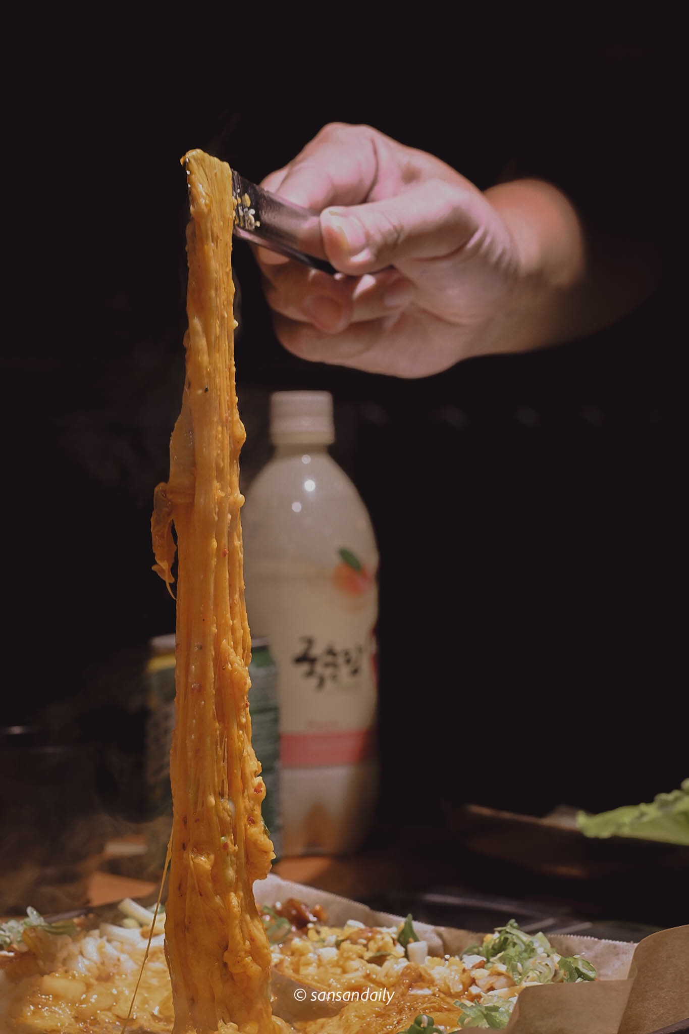 融化的起司瀑布被夾子拉到空中