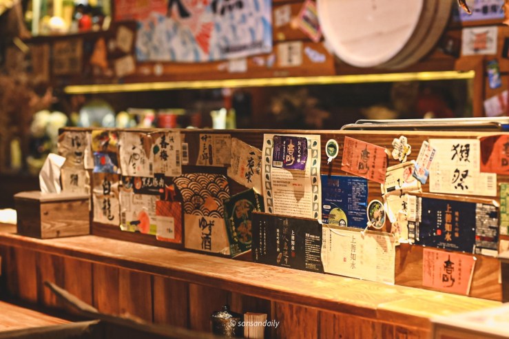 貼滿酒標的板前座位區 微風建一食堂