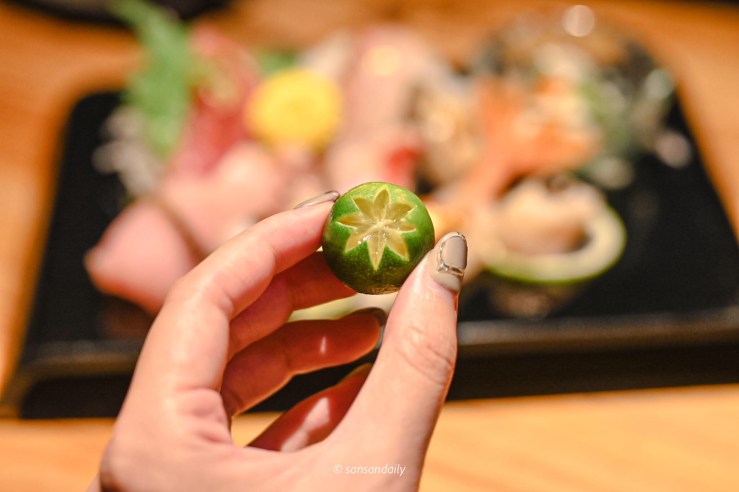 生魚片拼盤附的雕花金桔特寫