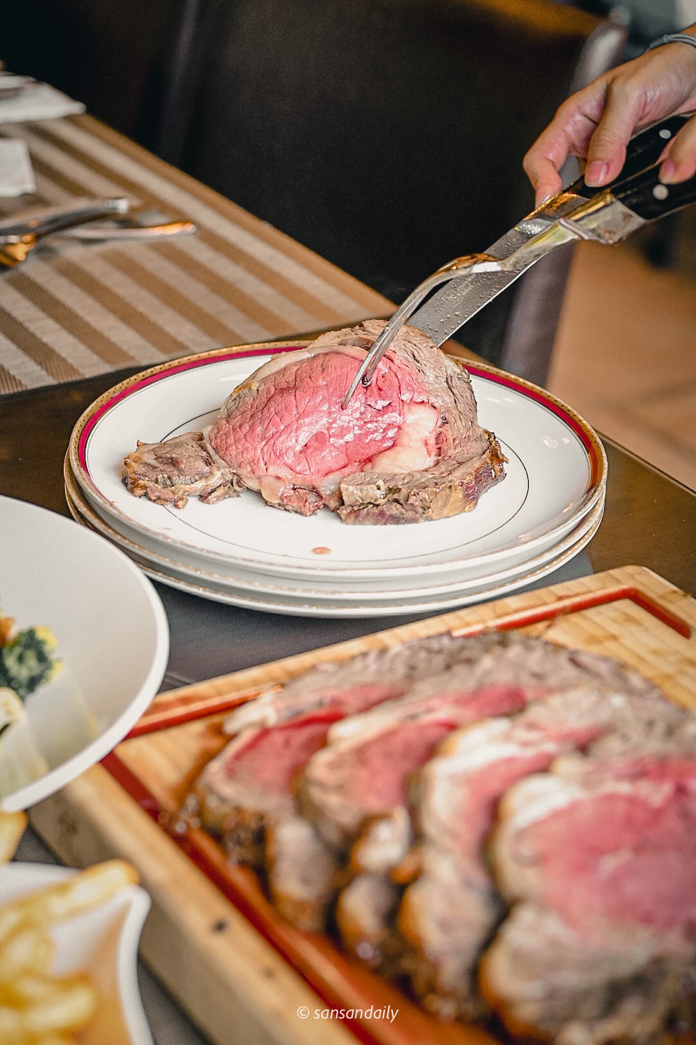 將Mr.Tom爐烤肋眼牛排切片分裝在精緻盤子上