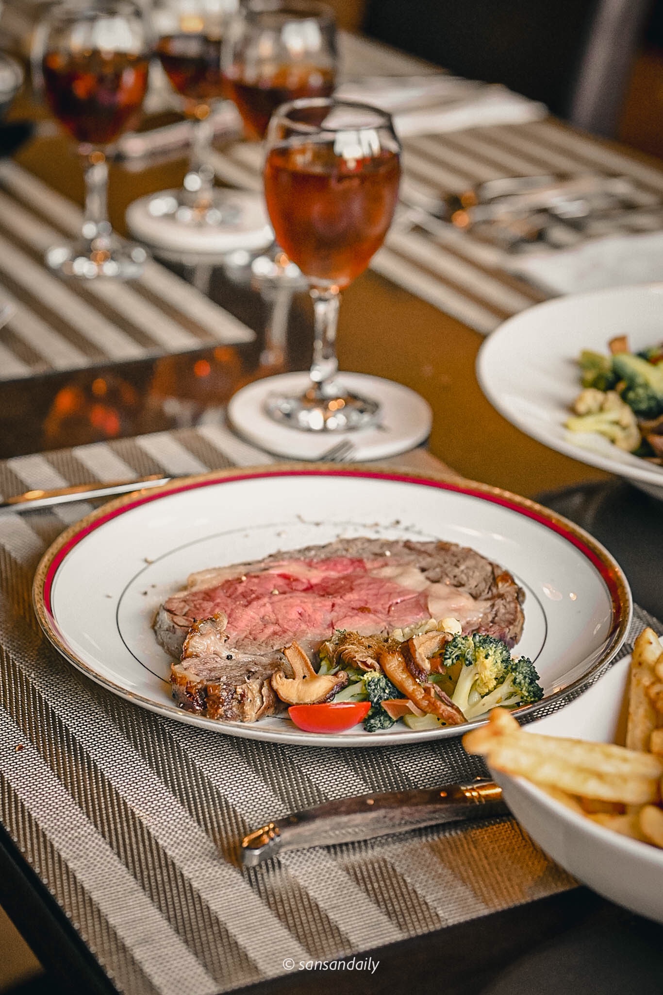 Mr.Tom爐烤肋眼牛排盛放在精緻盤中 玻璃杯