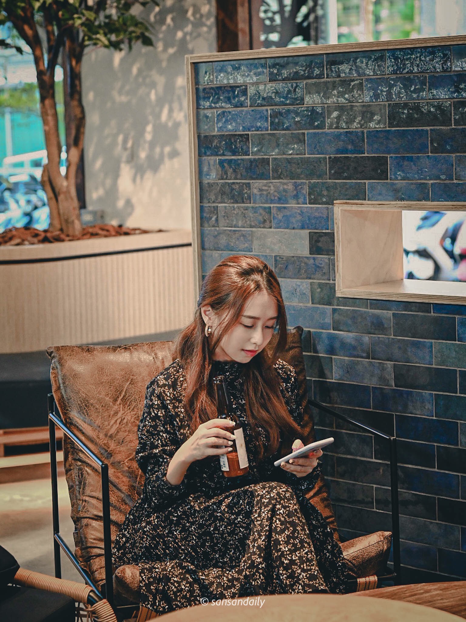 GUMGUM Beer & Wings女子坐在單人椅中滑手機喝啤酒情境圖