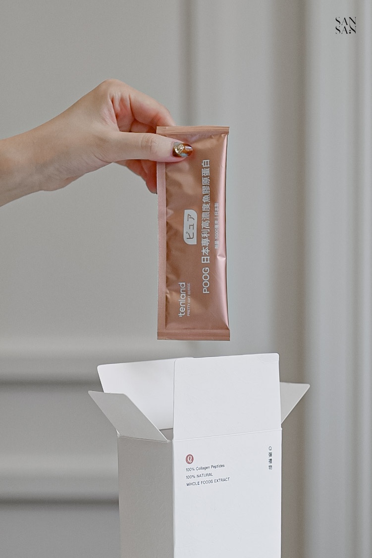 一隻手從白色盒裝拿出一包橘粉色單包裝膠原蛋白