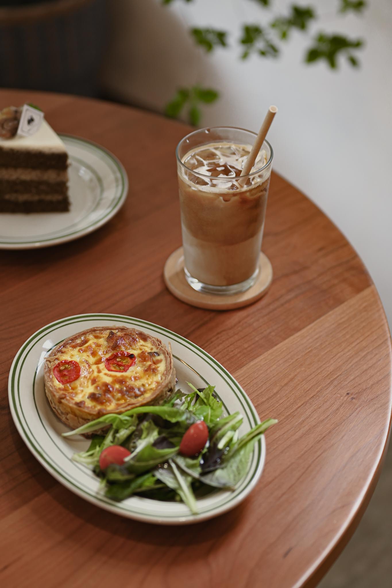 桌上有一盤圓鹹派附生菜沙拉 和一杯飲品
