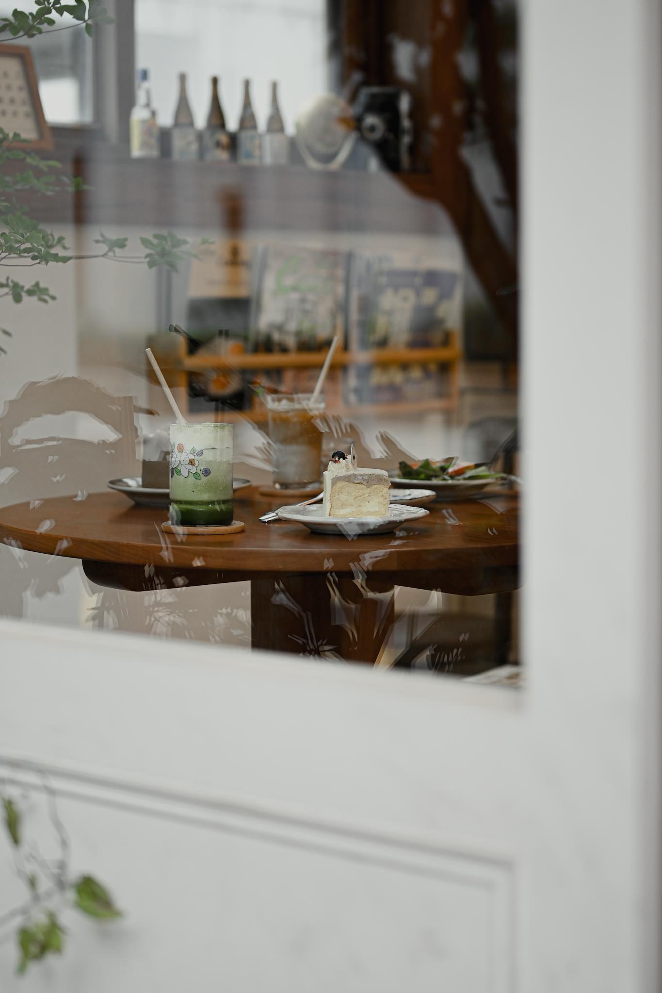 窗外往室內看的畫面 木桌上有餐點
