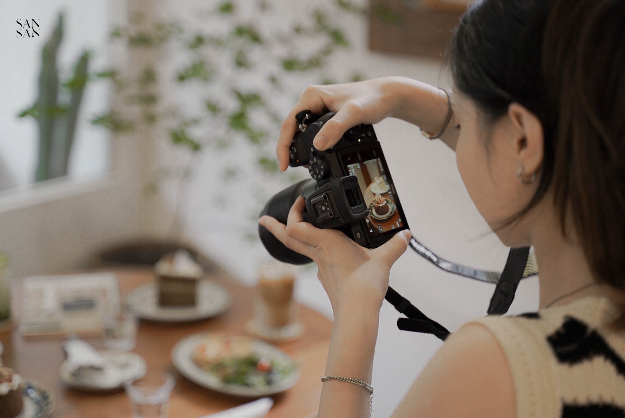 人物拿相機拍攝餐桌畫面