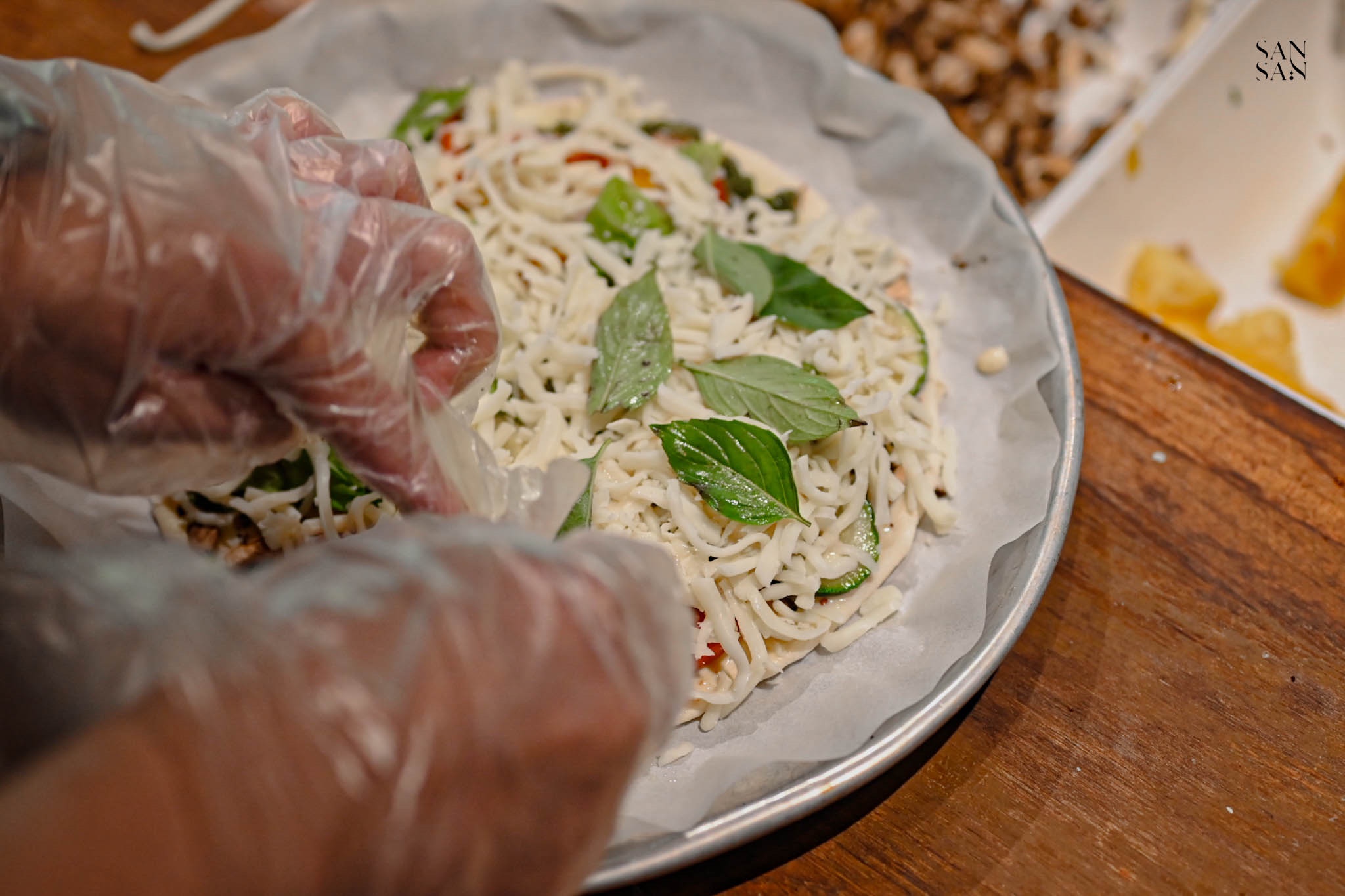 在披薩上放羅勒葉特寫