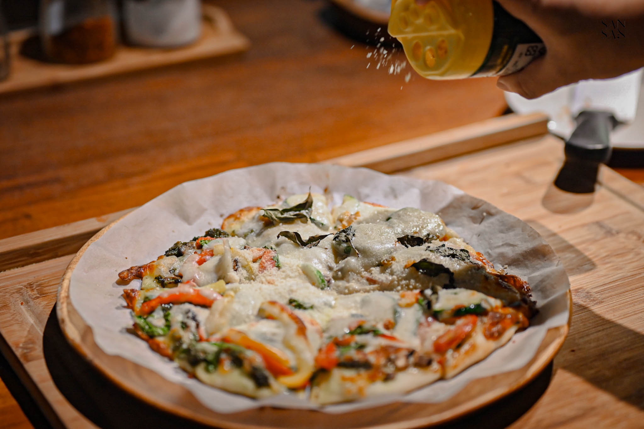 起司粉灑在披薩上的畫面