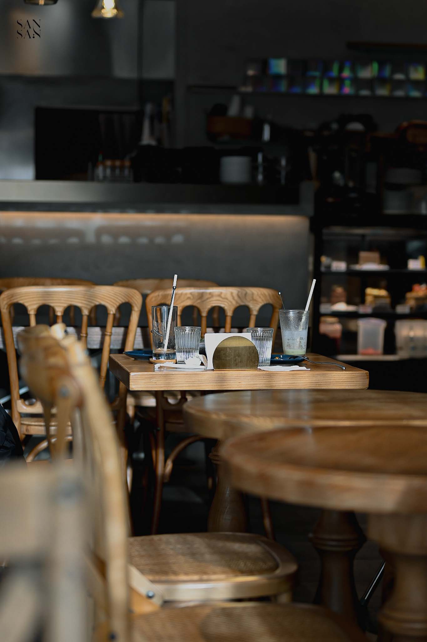 餐廳裡許多木桌椅 桌上擺著喝完的飲料杯特寫