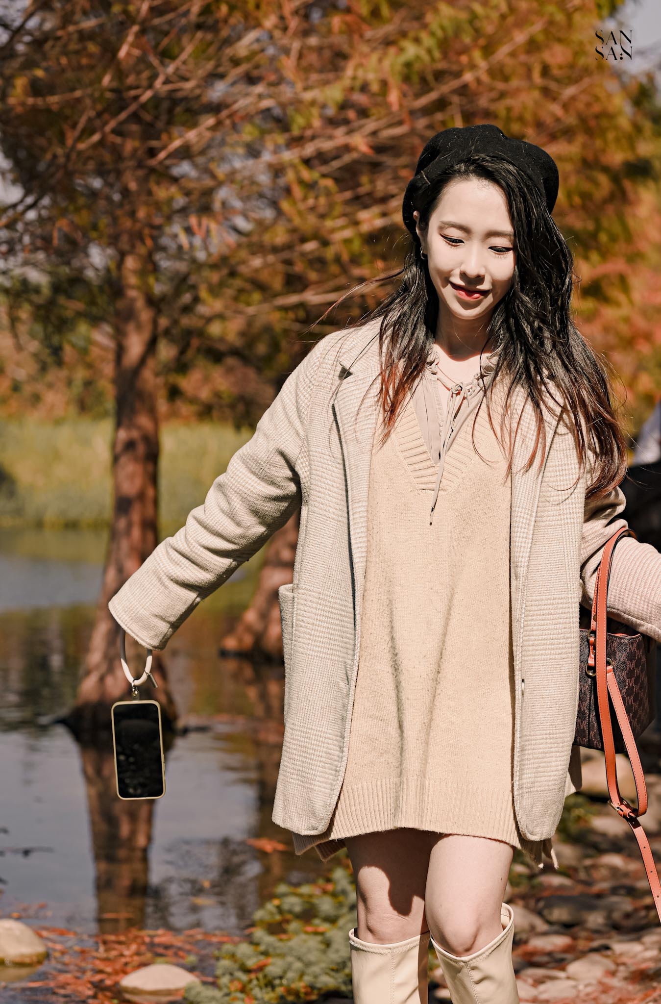 女人為笑低頭往前走的畫面 背景落羽松和濕地