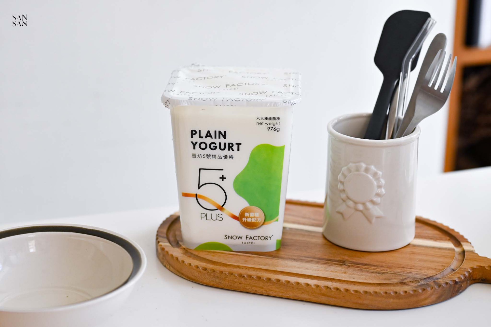 100%高品質純天然鮮乳製作的雪坊5號精品優格，擺放在一個精緻的木托盤上