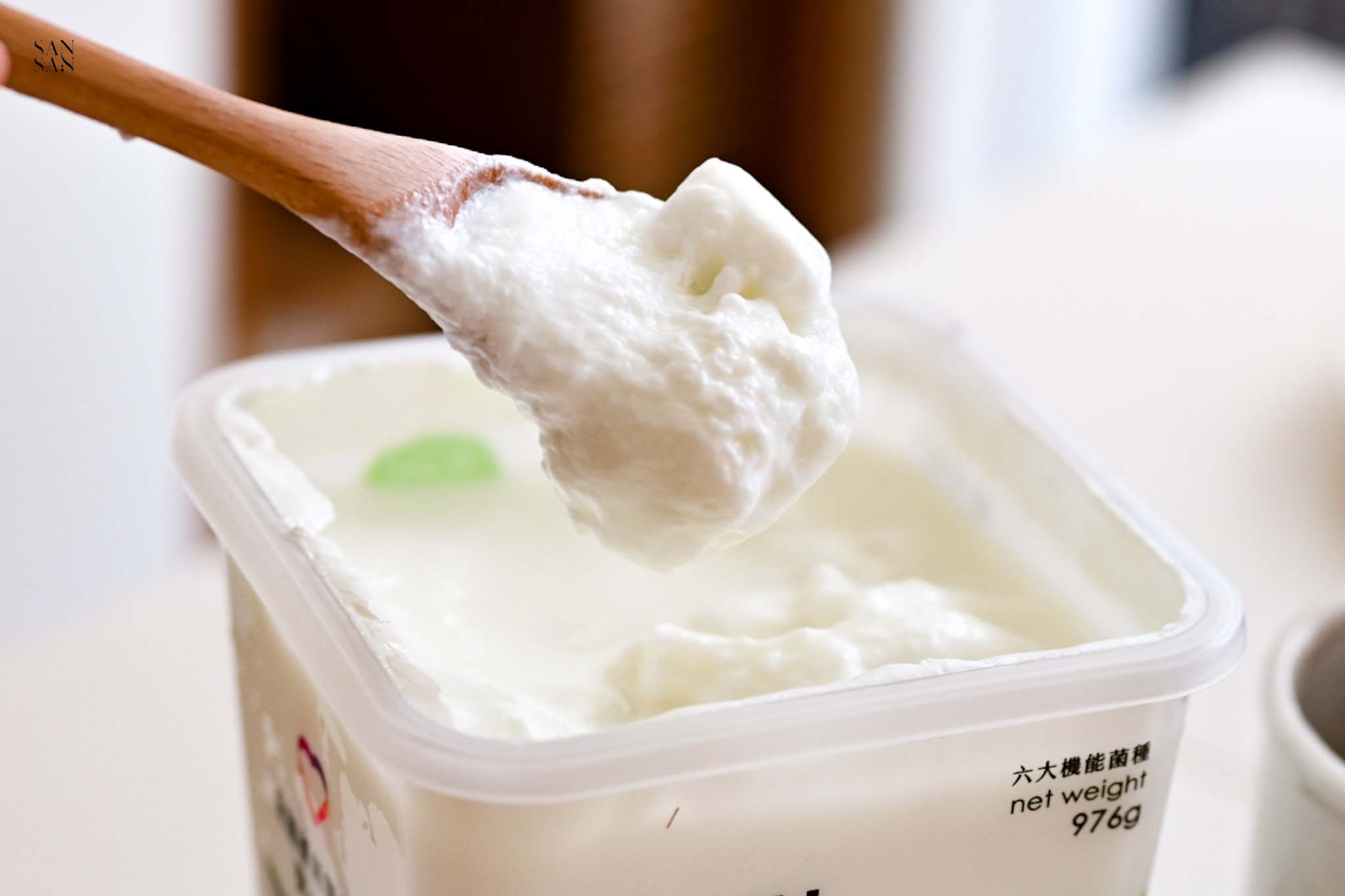 在藥廠等級的無塵室環境製作的雪坊5號精品優格，以木湯匙從罐中舀出一匙