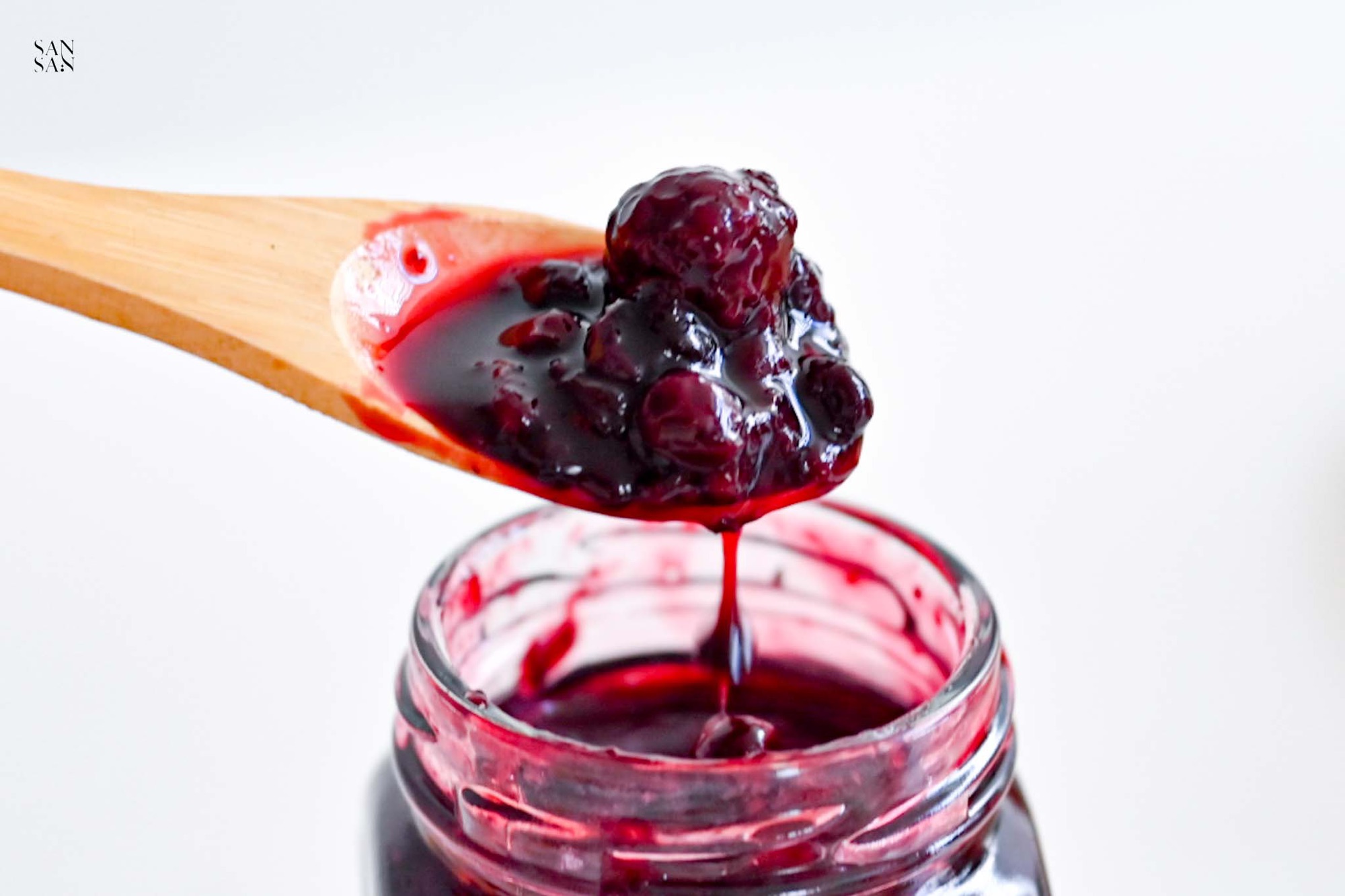 木湯匙從果醬瓶中舀出一杓滿是果肉的果醬，水果含量高達70%以上