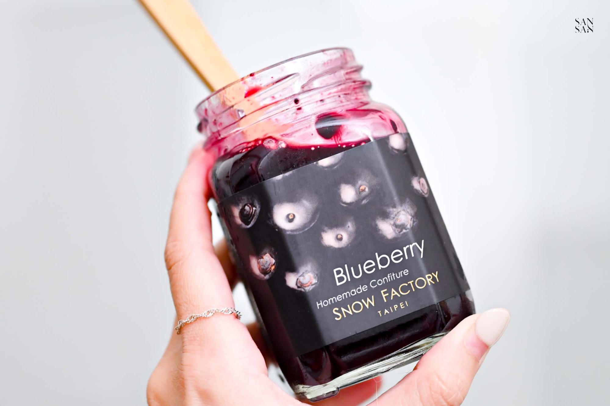 我拿著一罐打開的 籃莓果醬