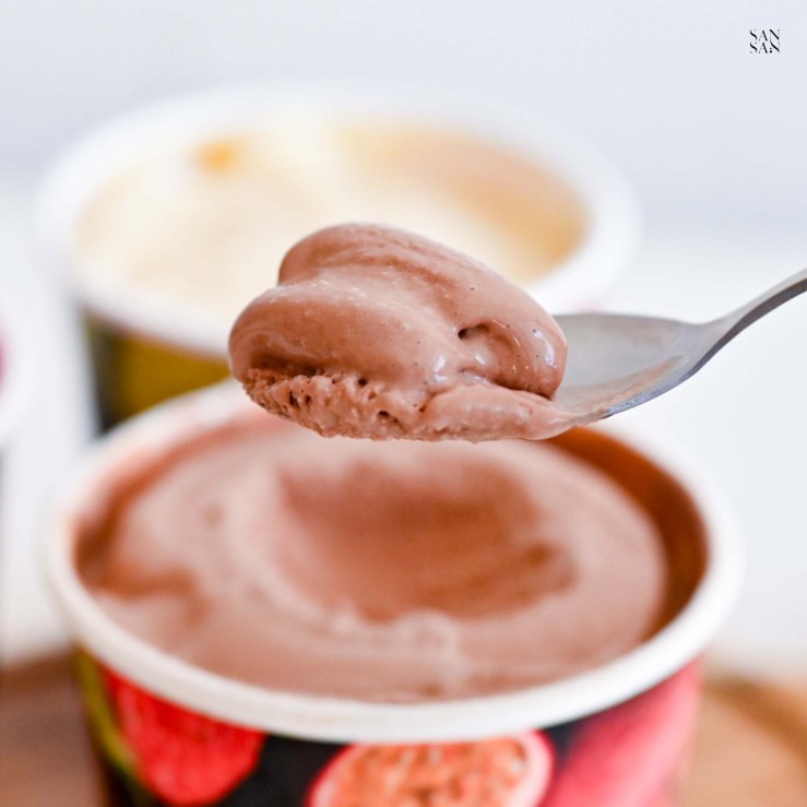 湯匙挖起一勺淺咖色的法芙娜巧克力冰淇淋，質地滑順