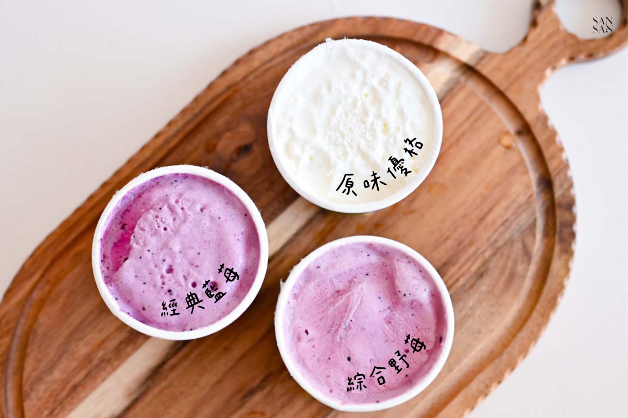 三罐開封展示內容物的優格冰淇淋，分別是：白色的原味優格、紫紅色的經典藍梅、粉紫色的綜合野莓