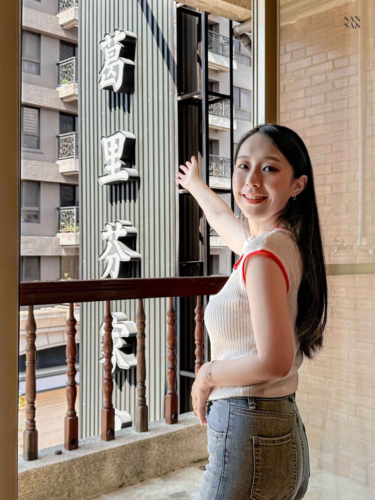 我微笑的看著鏡頭 一手指著桃園平鎮家具推薦的葛里芬家具招牌